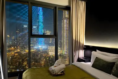 a bedroom with a large window with a view of a city at Luxury At The Top- Iconic Burj Views-Dubai Mall Access 2BR by Maxx Value Homes in Dubai
