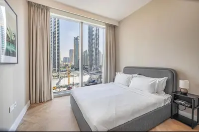 a bedroom with a large bed and a large window at Apartment Downtown Dubai in Dubai