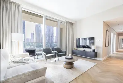a living room with a couch and a table and some chairs at Apartment Downtown Dubai in Dubai