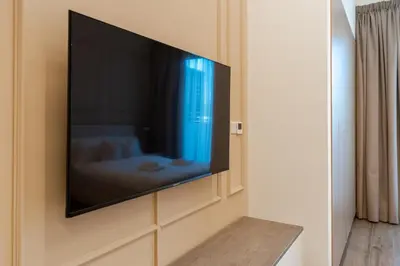 a flat screen tv on a wall in a bedroom at Urban Studio With Pool & Tennis Court in Dubai