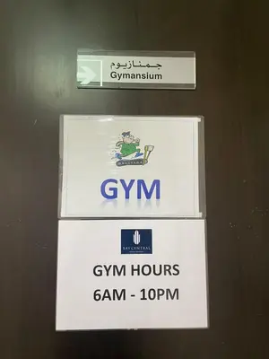 a sign that says gym hours and gm honors at Lake & Beach view Studio in the Center of Marina in Dubai
