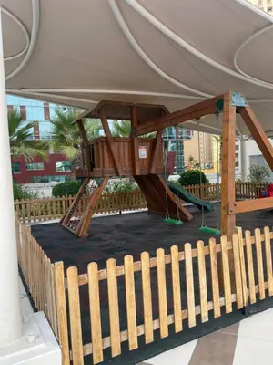 a playground in a building with a wooden fence at Lake & Beach view Studio in the Center of Marina in Dubai