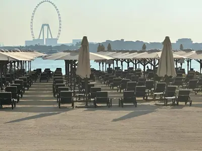 a bunch of chairs and umbrellas on a beach at Infinity Pool Studio in Palm Jumeirah on Exclusive West Beach in Dubai