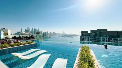 a swimming pool with chaise lounges on a building at Infinity Pool Studio in Palm Jumeirah on Exclusive West Beach in Dubai