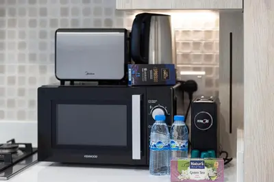 a microwave sitting on top of a counter with water bottles at Infinity Pool Studio in Palm Jumeirah on Exclusive West Beach in Dubai
