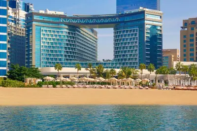 a beach with umbrellas and hotels in the city at Infinity Pool Studio in Palm Jumeirah on Exclusive West Beach in Dubai