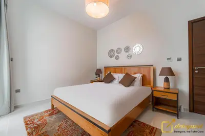a bedroom with a bed and a clock on the wall at Prestine 3BR Villa in DH2 by deleguest in Dubai