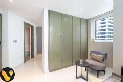 a living room with a chair and a table at Vogue Business Bay Damac Maison Prive near Burj Khalifa and Dubai Mall, Studio Apartment with Canal and City View, Access to all Amenities in Dubai