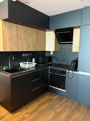 a kitchen with black cabinets and a sink and a dishwasher at Sea and Dubai Ain view Close to Private Beach in Dubai