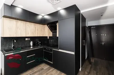 a kitchen with black appliances and wooden cabinets at Sea and Dubai Ain view Close to Private Beach in Dubai