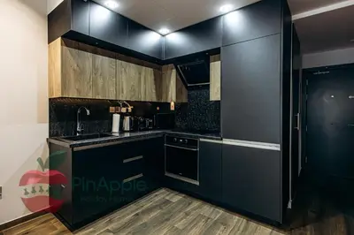 a kitchen with black cabinets and wooden floors at Sea and Dubai Ain view Close to Private Beach in Dubai