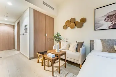 a living room with a bed and a couch at City View Studio Minutes Drive to Burj Khalifa, Azizi Riviera 43, Al Merkadh by Deluxe Holiday Homes in Dubai