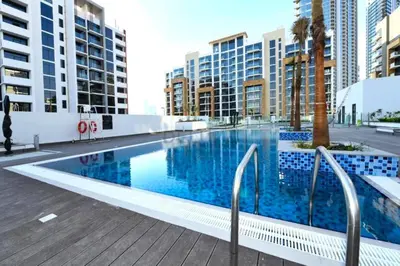 a large swimming pool in a city with tall buildings at City View Studio Minutes Drive to Burj Khalifa, Azizi Riviera 43, Al Merkadh by Deluxe Holiday Homes in Dubai