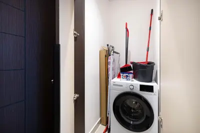 a washing machine in a room next to a door at Modern 1-Bedroom Apartment with Stunning Burj Khalifa and city Views in Dubai