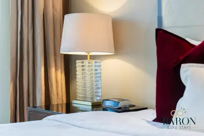 a lamp on a night stand next to a bed at The Captivating in Dubai