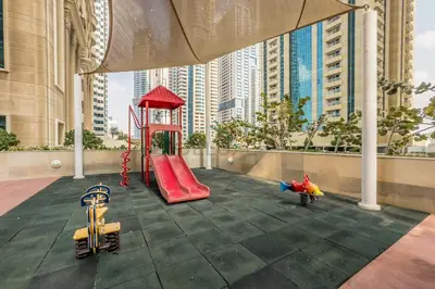 a playground with a red slide in a city at Renovated Unit with Skyscraper Views, Close to JBR Beach, Elite Residence, Dubai Marina by Deluxe Holiday Homes in Dubai