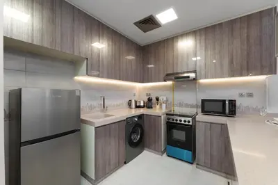 a kitchen with a refrigerator and a stove top oven at Maison Privee - Modern Living with Premium Amenities close to Marina in Dubai