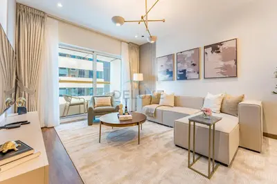 a living room with a couch and a table at Refurbished 1BR High-Floor Unit with Partial City & Sea Views, Walking Distance to the Beach, Elite Residence, Dubai Marina by Deluxe Holiday Homes in Dubai