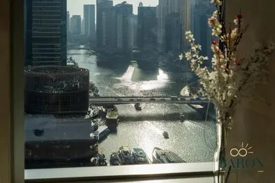 a window with a view of a river and a city at The Exquisite in Dubai