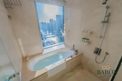 a bathroom with a bath tub and a window at The Exquisite in Dubai