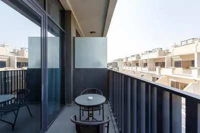 a balcony with a table and chairs on a building at Upgraded Brand New Studio in Belgravia 2, JVC - Allsopp & Allsopp in Dubai