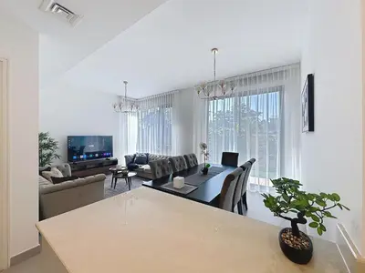 a living room with a table and a couch at Modern Five Bedroom Villa with BBQ and Garden in Dubai