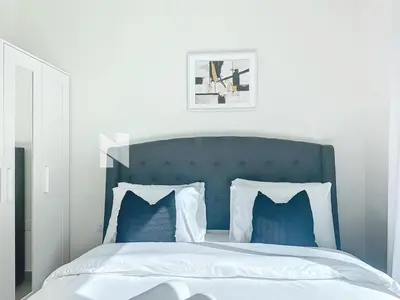 a bedroom with a blue and white bed with blue pillows at Modern Five Bedroom Villa with BBQ and Garden in Dubai