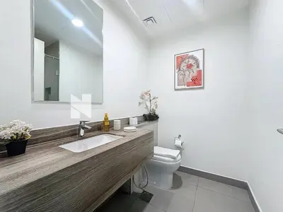 a bathroom with a sink and a toilet and a mirror at Modern Five Bedroom Villa with BBQ and Garden in Dubai