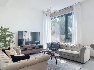 a living room with a couch and a flat screen tv at Modern Five Bedroom Villa with BBQ and Garden in Dubai