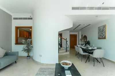 a living room with a couch and a table at HAVN - 2-Storey Apartment with Dubai Marina Views in Dubai