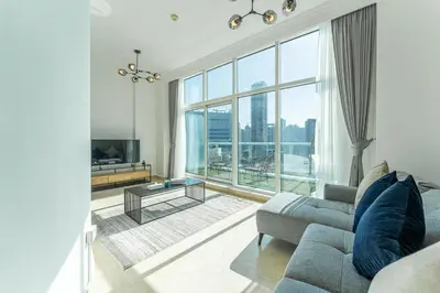 a living room with a couch and a large window at HAVN - 2-Storey Apartment with Dubai Marina Views in Dubai