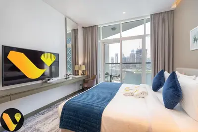 a hotel room with a large bed and a tv at Vogue Business Bay Damac Maison Prive near Burj Khalifa and Dubai Mall, Studio Apartment with Balcony, Canal and City view, Access to all Amenities in Dubai