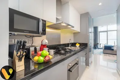 a kitchen with a bowl of fruit on a counter at Vogue Business Bay Damac Maison Prive near Burj Khalifa and Dubai Mall, Studio Apartment with Balcony, Canal and City view, Access to all Amenities in Dubai