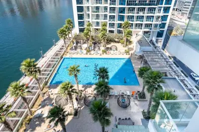 an overhead view of a pool with palm trees and a building at Vogue Business Bay Damac Maison Prive near Burj Khalifa and Dubai Mall, Studio Apartment with Balcony, Canal and City view, Access to all Amenities in Dubai