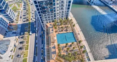 an aerial view of a building with a swimming pool at Vogue Business Bay Damac Maison Prive near Burj Khalifa and Dubai Mall, Studio Apartment with Balcony, Canal and City view, Access to all Amenities in Dubai