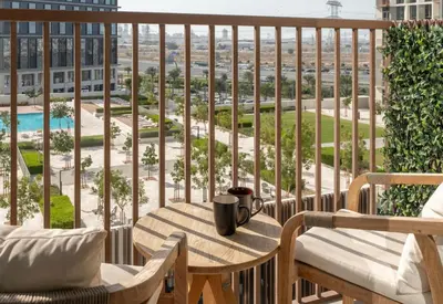 a balcony with a table and chairs and a view of the city at 2 bedroom apartment Dubai Hills in Dubai