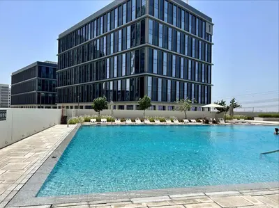 a swimming pool in front of a building at 2 bedroom apartment Dubai Hills in Dubai