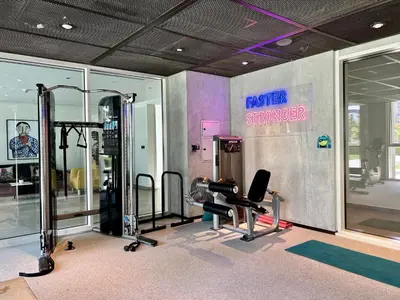 a fitness room with a gym with a mirror stronger sign at 2 bedroom apartment Dubai Hills in Dubai