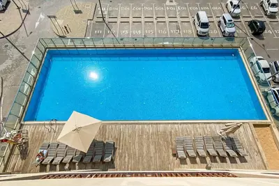 an overhead view of a swimming pool with chairs and an umbrella at Silkhaus Cozy Seashore Studio in Palm Jumeirah in Dubai