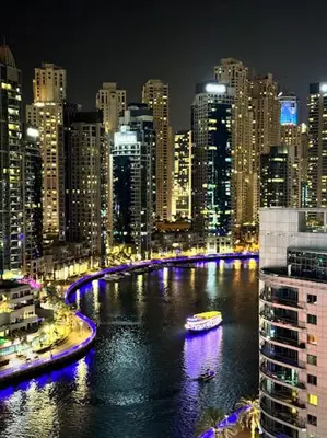 a view of a city at night with a river at Big Studio Apartment in Dubai Marina Walking to JBR Beach, Cruise and DMCC Metro in Dubai