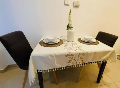 a table with two chairs and a white table cloth at Big Studio Apartment in Dubai Marina Walking to JBR Beach, Cruise and DMCC Metro in Dubai