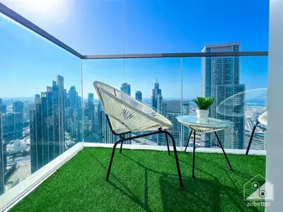 a chair and a table on a balcony with a view at Luxury 1BR at Grande Downtown with Iconic Views in Dubai