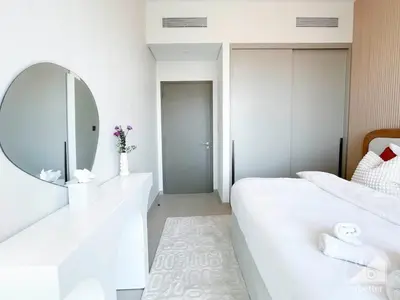 a white bedroom with a mirror and a white bed at Luxury 1BR at Grande Downtown with Iconic Views in Dubai