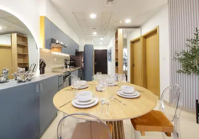 a kitchen with a wooden table with plates and wine glasses at Lux 1BR Apt with BurjKhalifa Views in DowntownDubai in Dubai