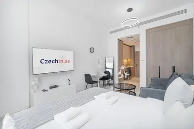 a white bedroom with a bed and a couch at Bright & Modern Studio - Legacy By Sunrise - Arjan in Dubai