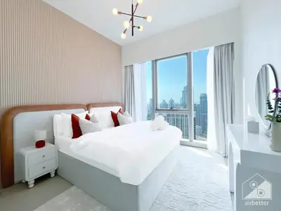 a bedroom with a white bed with a large window at Grande Luxury 1B With Balcony & City Views in Dubai