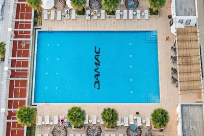 an overhead view of a large swimming pool with tables and chairs at Vogue Business Bay Damac Maison Prive near Burj Khalifa and Dubai Mall, Studio Apartment with Balcony, Canal and City View, Access to all Amenities in Dubai