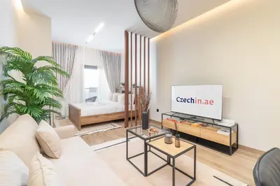a living room with a couch and a tv at Smartly Designed Studio in JVC in Dubai