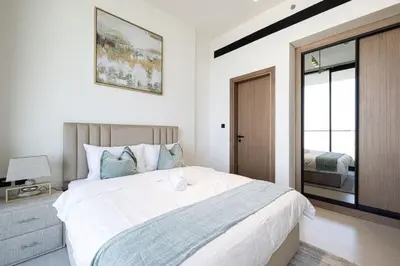 a bedroom with a large white bed and a window at Binghatti House in JVC - New Apartment in Dubai