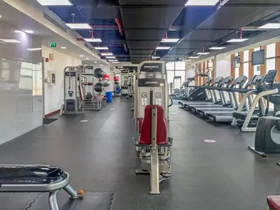 a gym with rows of treadmills and machines at Chic Waterfront Studio in Palm Views West in Dubai